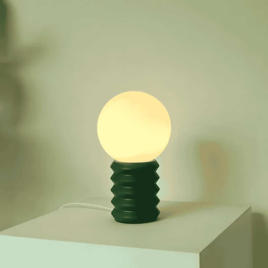 Rippled wooden green lamp on table